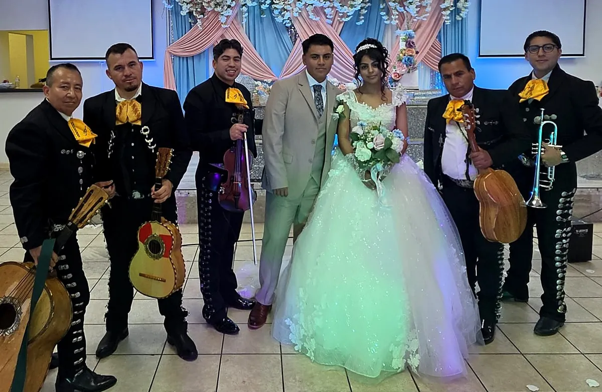 Los novios rodeados por los músicos del mariachi el día de su boda
