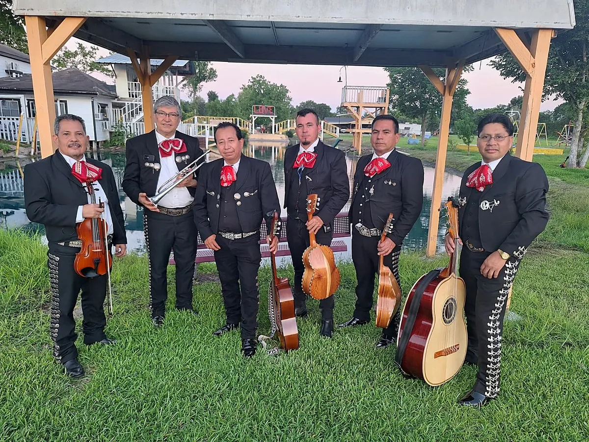 Los siete músicos de Sonido Celestial con violín, trompeta, guitarrón y guitarras bajo una pérgola, sobre el césped
